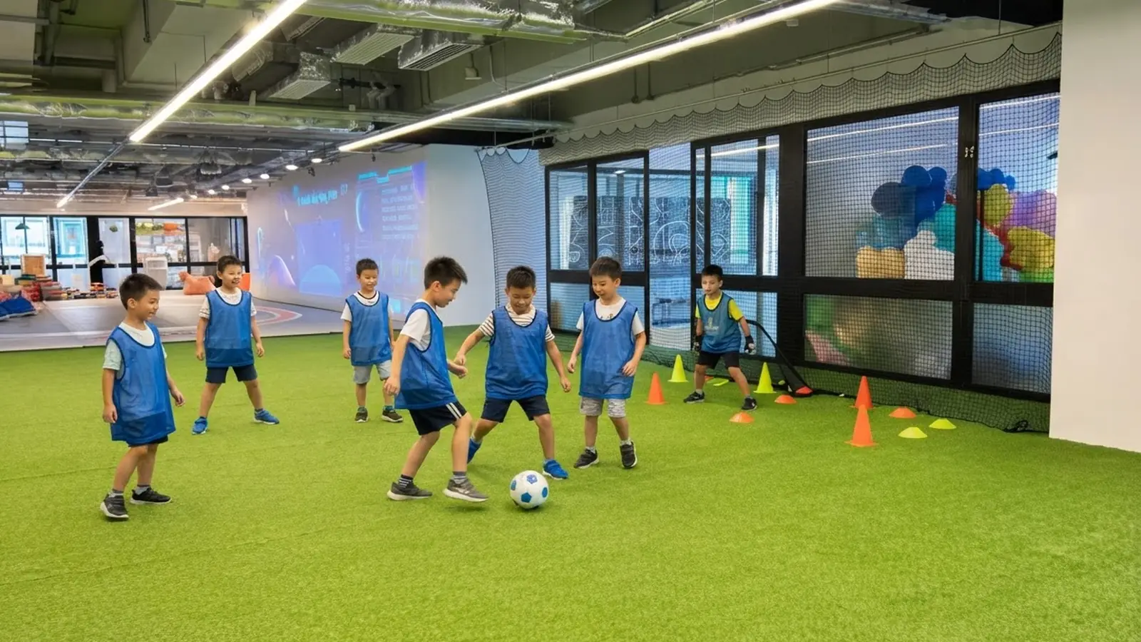 Children in blue kit lined up for a coaching session on the indoor turf pitch at MosKiddo
